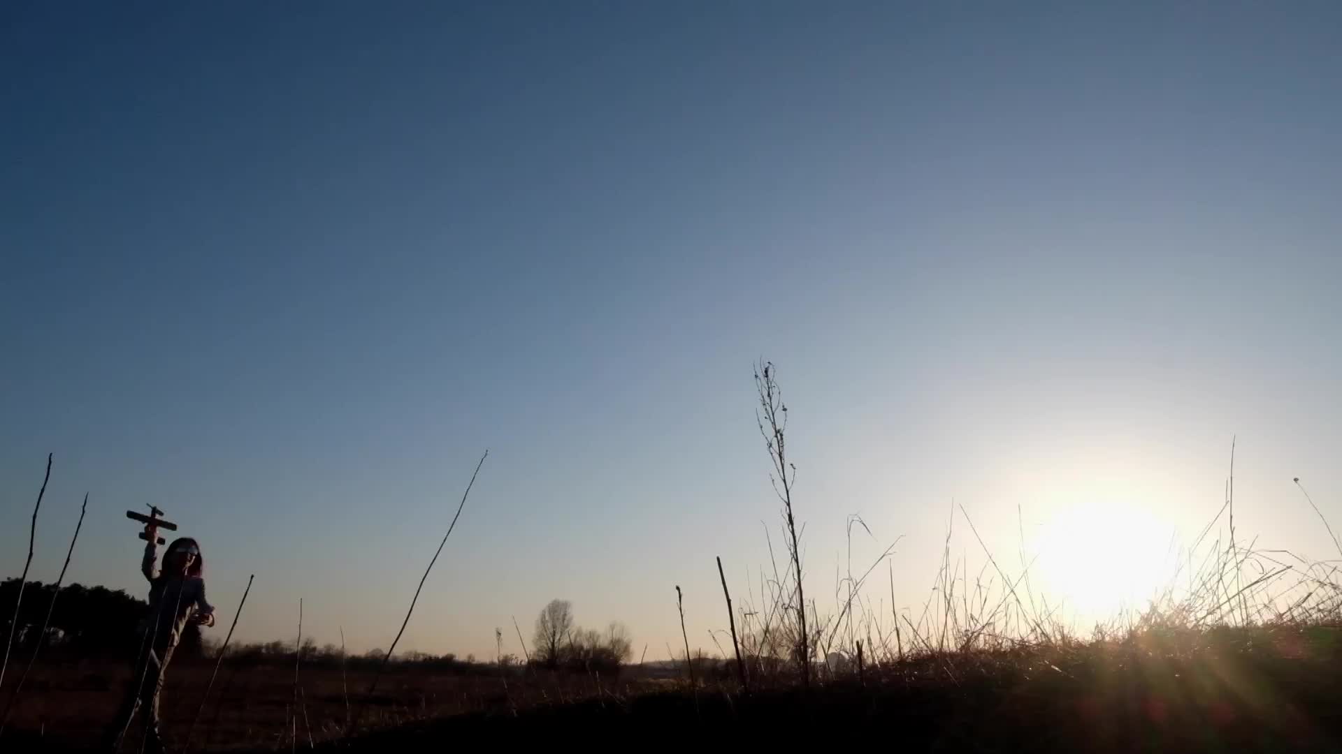 小女孩在草地上奔跑着玩飞机模型