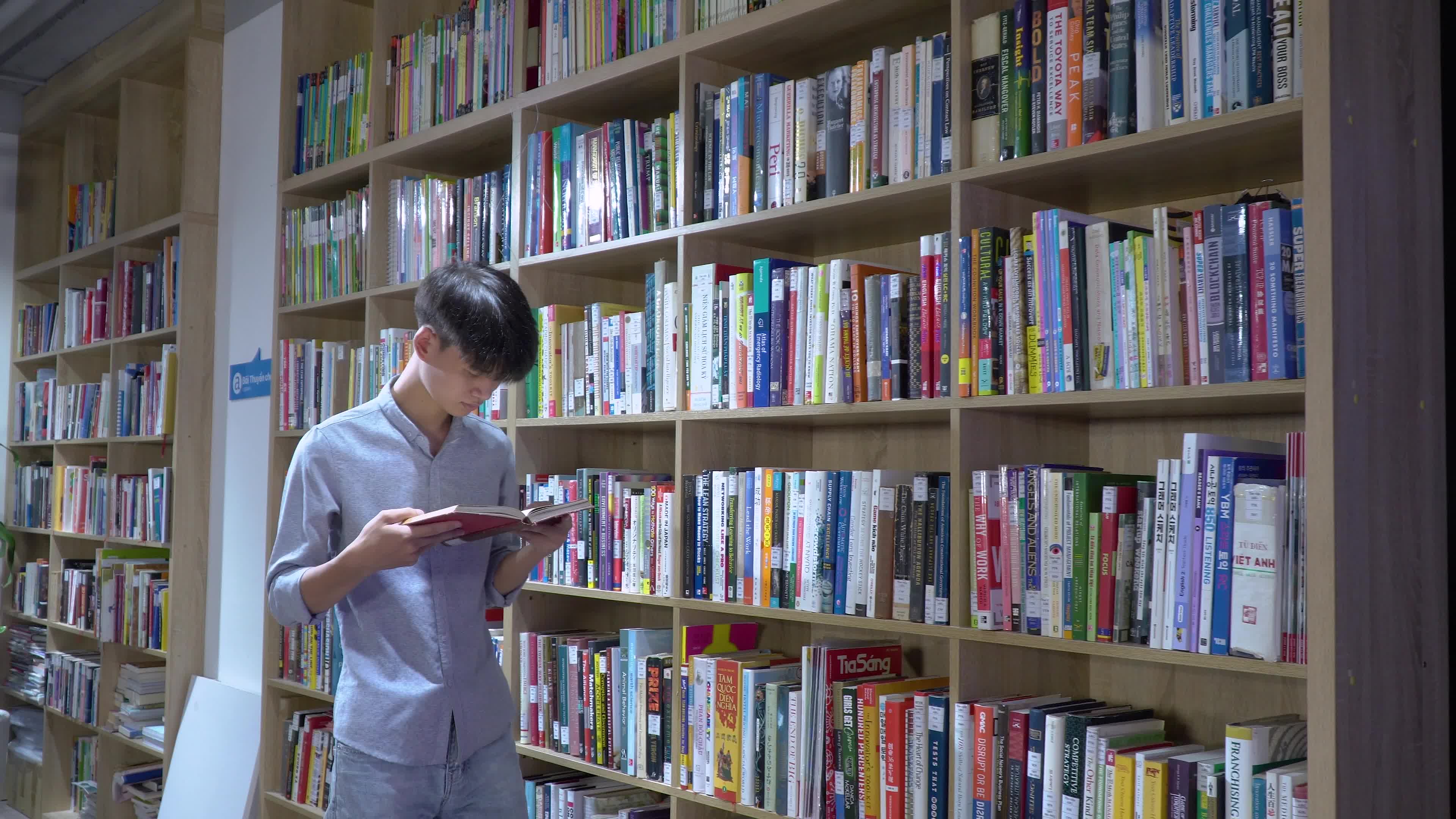 男生在书架旁边看书
