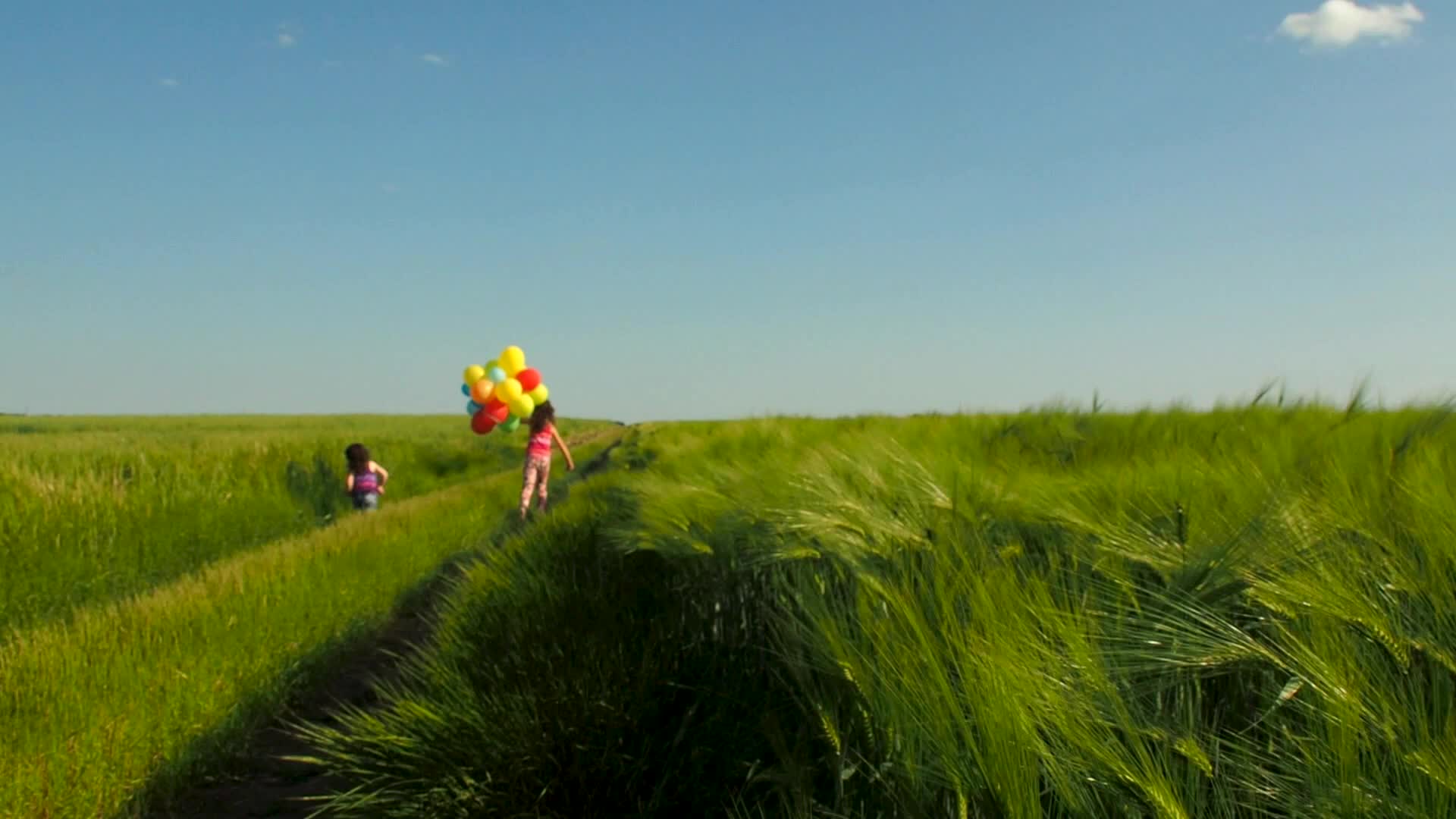 小女孩拿着气球奔跑在农田里